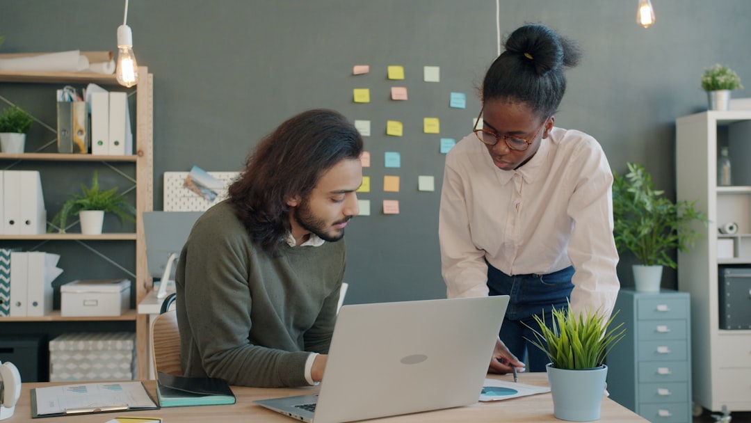Team collaboration around an office desk — Bitwarden Family ($40/year for 6 users) and Business ($36/user/year) tiers compared